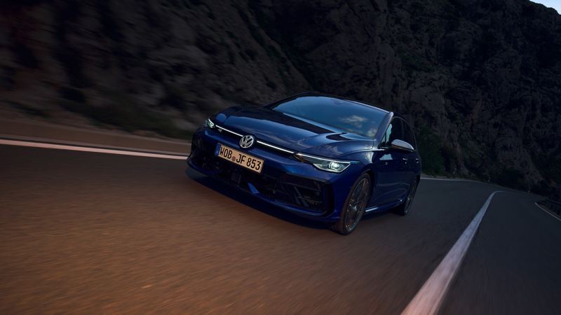 Une VW Golf R sur une route au crépuscule les phares LED et le bandeau LED transversal étant allumés