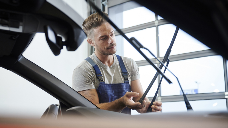VW Servicemitarbeiter prüft VW Scheibenwischer – Volkswagen Auto Ersatzteile