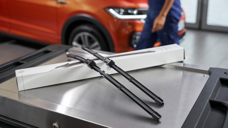 ローラーコンテナに載せられたフォルクスワーゲン純正エアロワイパーとパッケージ。背後にはVW T-Cross