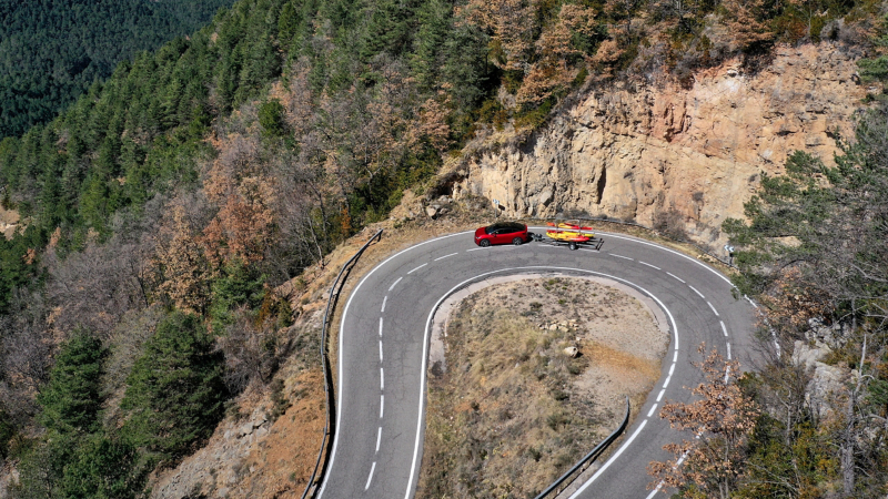 VW ID.5 GTX with kayaks on a trailer driving round a bend – driving with a trailer