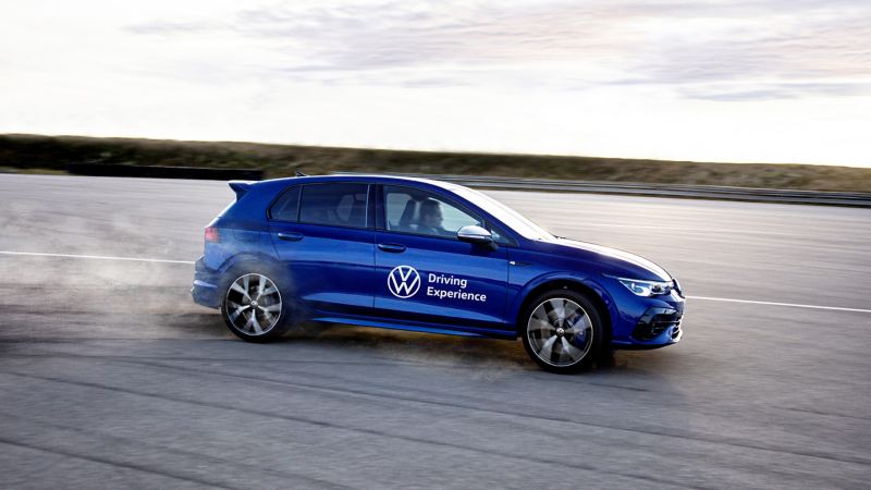 Ein Fahrer genießt das Erlebnis einer Dynamic Driver Experience in einem blauen Volkswagen