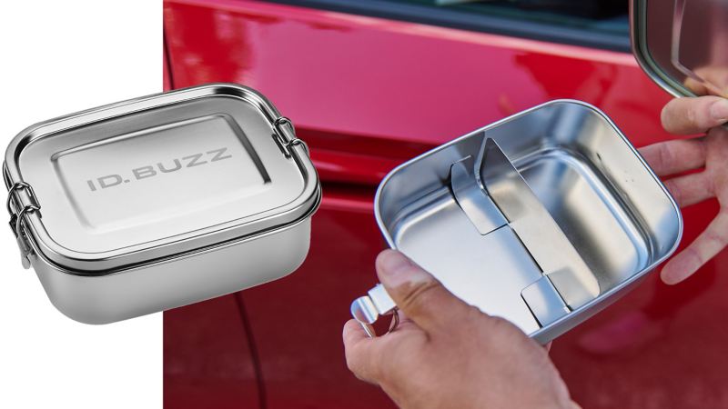 Jemand hält einen Essensbehälter aus Edelstahl mit „ID. Buzz“-Gravur in den Händen – VW Zubehör