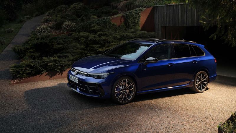 Une VW Golf R Variant garée devant un garage ouvert