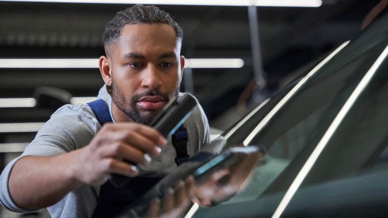 フロントガラスに傷が付いていないか検査するVWのサービススタッフ - ガラス修理サービス