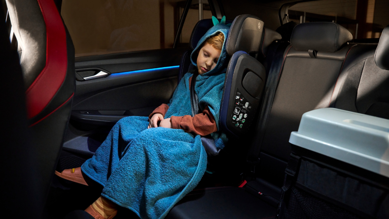 Kind mit Kuscheldecke in einem VW Zubehör Kindersitz