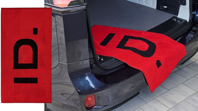 Handtuch mit „ID.“-Schriftzug hängt über Kofferraumklappe eines VW Autos