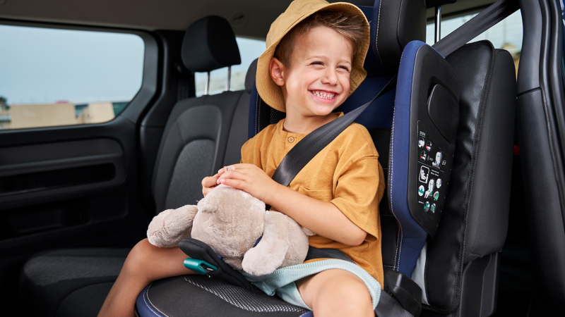 Kind mit Kuscheltier im Kindersitz von Volkswagen Zubehör