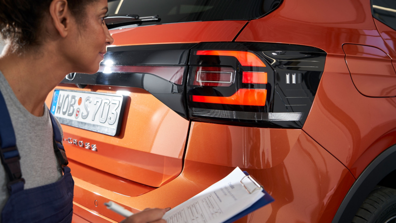 VW service employee with checklist checks a VW T-Cross