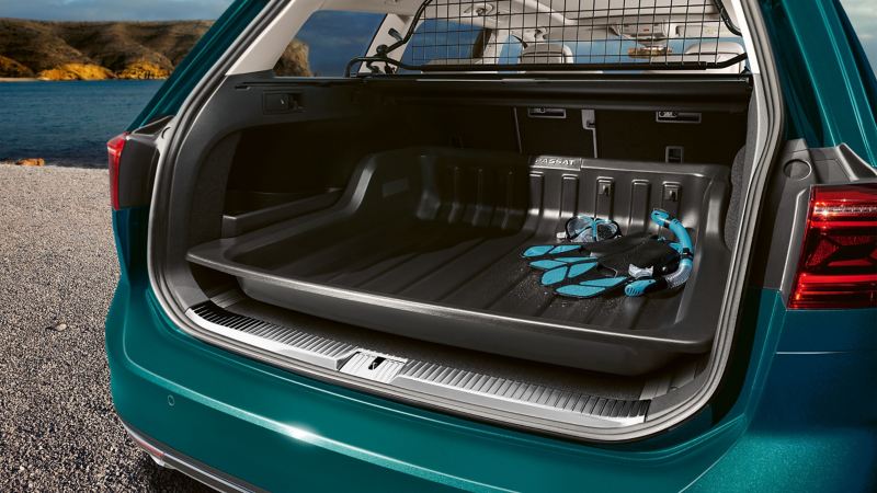 A detailed view of a luggage grid and a large bag in the trunk of a blue VW Polo 5 – Volkswagen Accessories