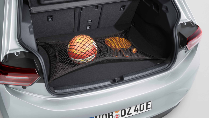 Volleyball, zwei Tischtennisschläger und Tischtennisball geschützt durch ein Gepäcknetz im Kofferraum eines VW ID.3 Neo