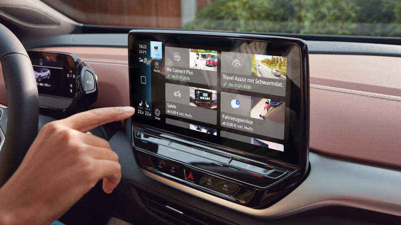 Nahaufnahme von Hand, die In-Car App im VW Infotainment-System benutzt.