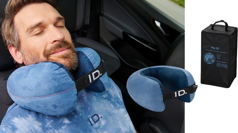 Mann schläft mit einem Nackenkissen auf dem Beifahrersitz – Nackenkissen und Transporttasche von VW Zubehör