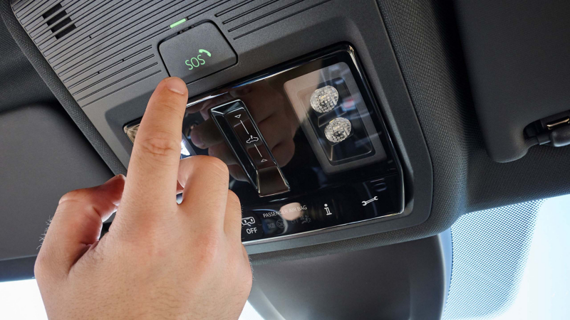 Mann betätigt „SOS“-Knopf im Dachhimmel eines VW Autos