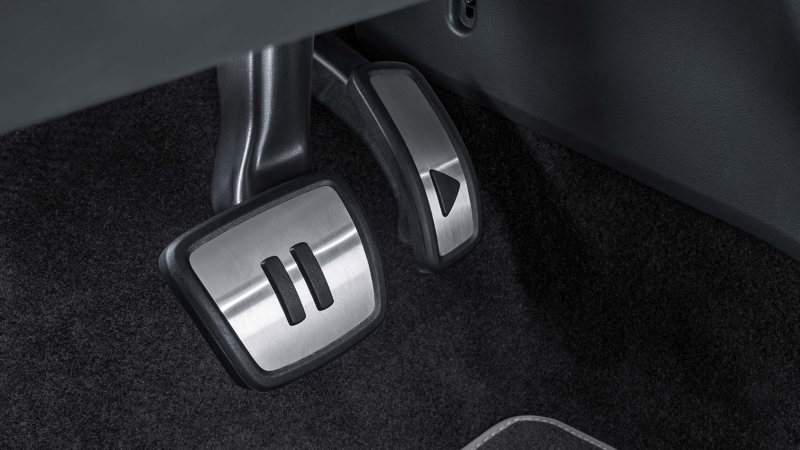 Pedalkappenset von VW Zubehör im Fußraum eines VW ID.3 Neo, auf den Pedalkappen sind „Play“- und „Pause“-Symbole zu sehen