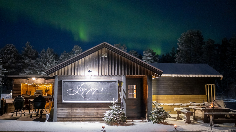 Blick auf verschneite Holzhütte – Restaurant JayJay´s im schwedischen Arvidsjaur 