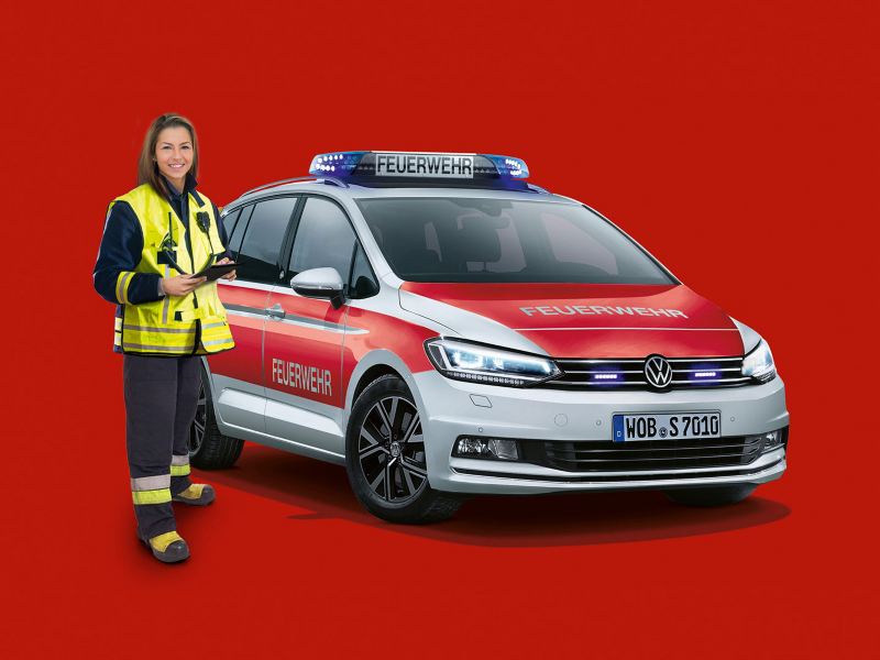 Eine Frau steht neben einem VW Rettungsfahrzeug