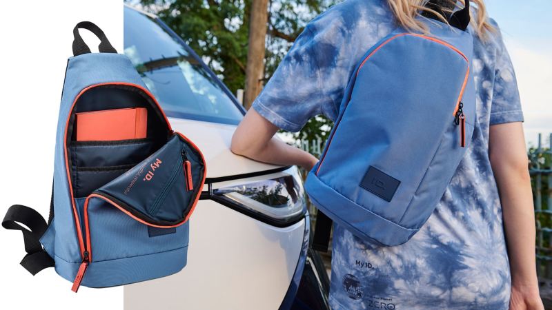 Eine Frau trägt eine Schultertasche aus der ID. Kollektion von Volkswagen Zubehör, im Hintergrund ein VW ID. Buzz