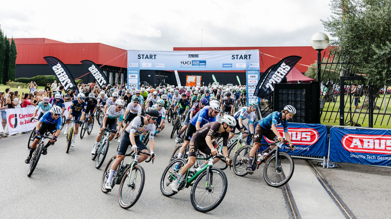 Radsportler fahren kurz nach dem Start um eine Kurve