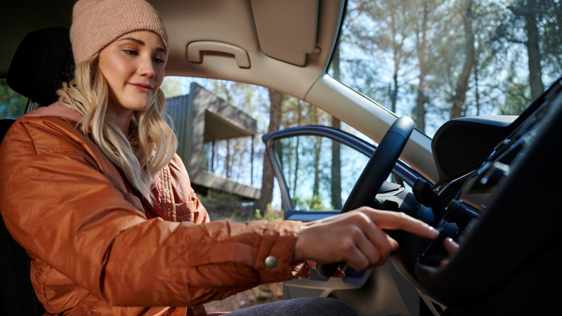 Frau bedient Standheizung im Infotainment-System in VW Auto