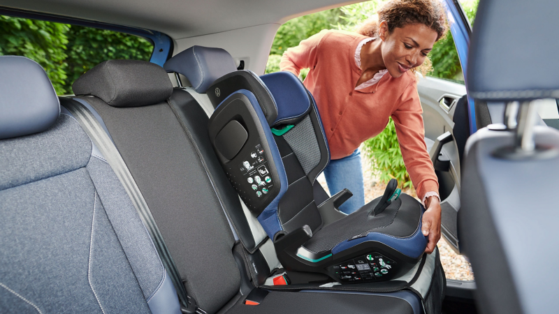 Frau befestigt VW Zubehör Kindersitz