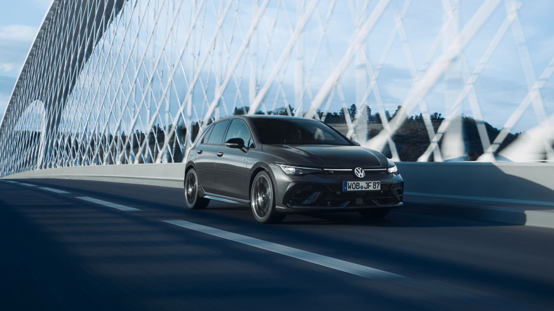 Golf R bleue stationnée devant un bâtiment au style industriel.
