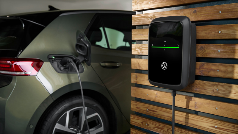 Detalle de un cargador conectado a un Volkswagen verde