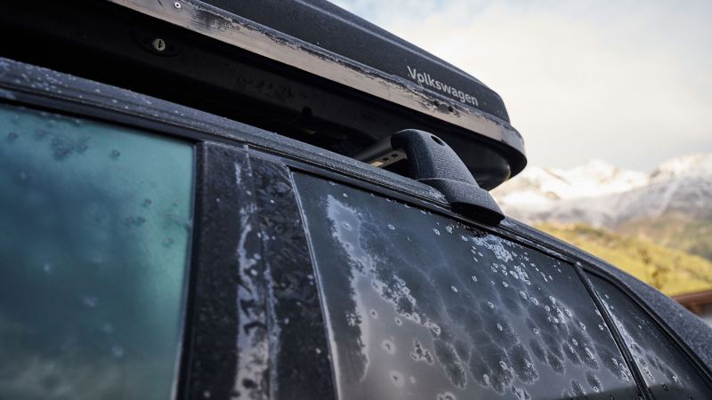 A Volkswagen with a roof box and frozen windows – VW winter care products