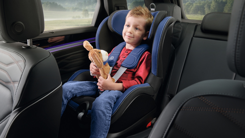 Junge mit Kuscheltier im Kindersitz „i-SIZE Trifix“ von VW Zubehör