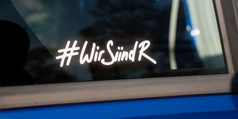 Ein „#WirSiindR“-Schriftzug ist auf der Scheibe eines VW Autos zu sehen