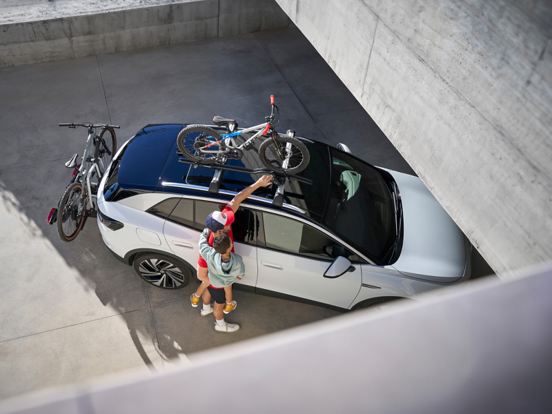 Man and child next to VW ID.4 that is equipped with VW Accessories – bicycle holder and bicycle carrier