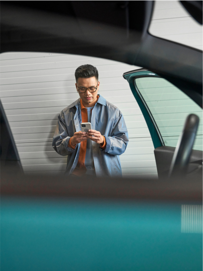 Man standing near VW vehicle.