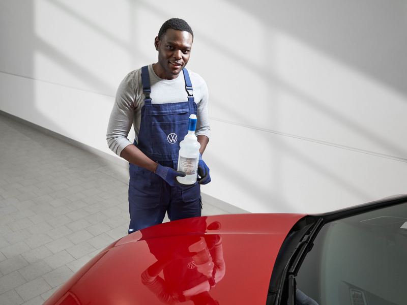 Λεπτομερής λήψη υπαλλήλου Service VW που κρατάει μια φιάλη AdBlue®