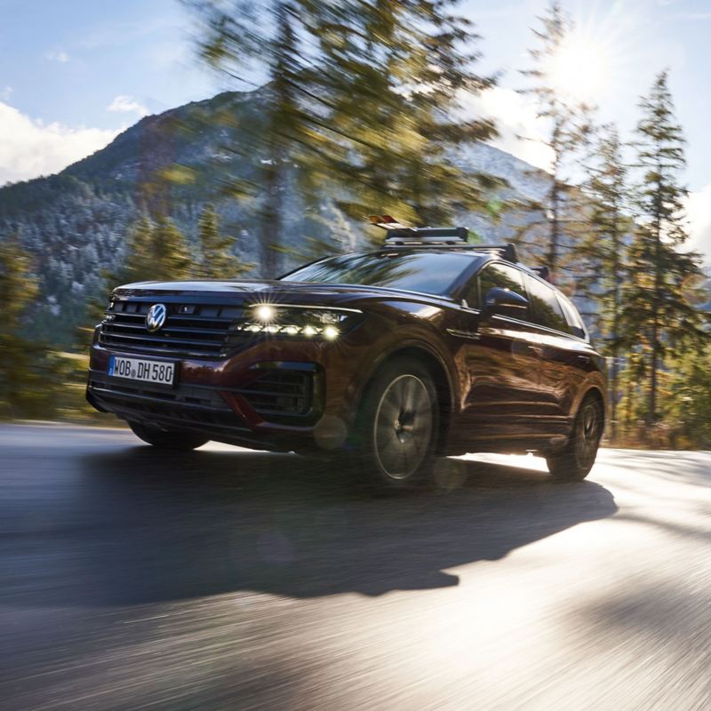 A Touareg on a country road, mountains in the background – all-season tyres