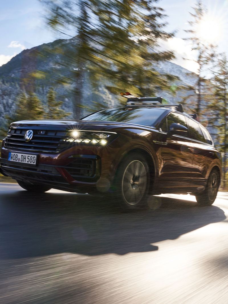 A Touareg on a country road, mountains in the background – all-season tyres