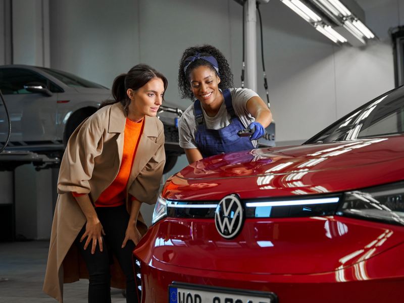 VW service employee and customer look at the paintwork of a VW ID.5 GTX