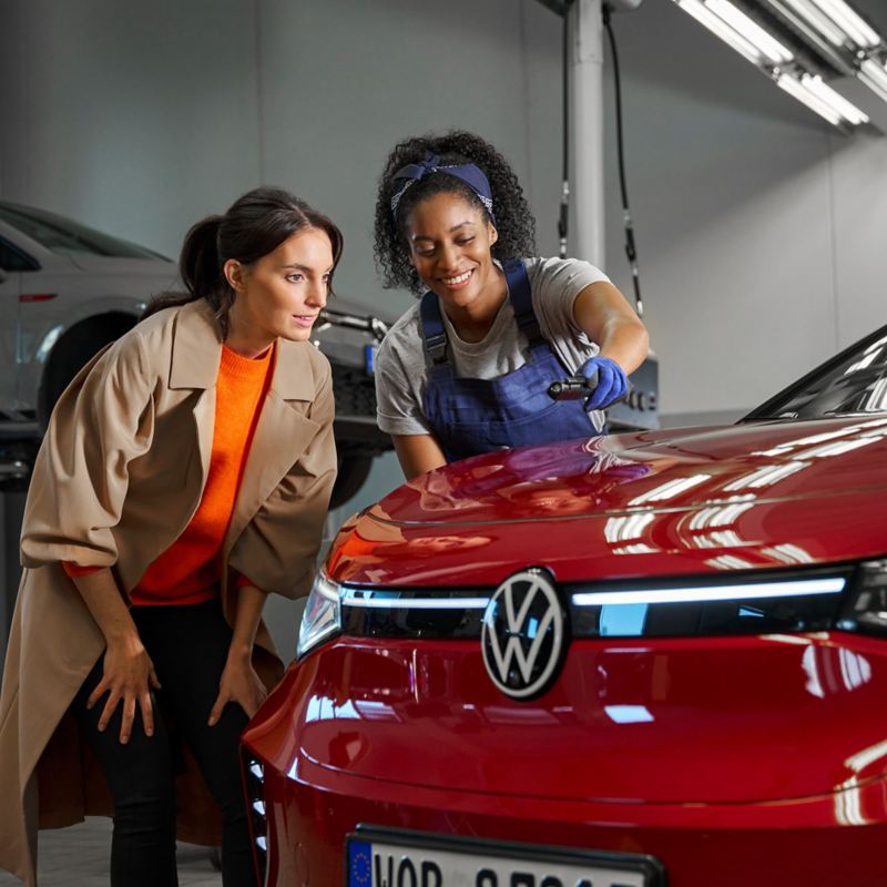 VW service employee and customer look at the paintwork of a VW ID.5 GTX