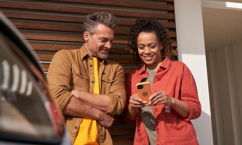 Eine Frau und ein Mann schauen sich das digitale Bordbuch auf dem Smartphone an