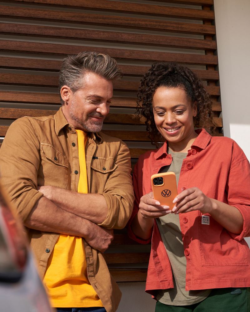 Eine Frau und ein Mann schauen sich auf einem Smartphone das Bordbuch an – digitale Betriebsanleitung