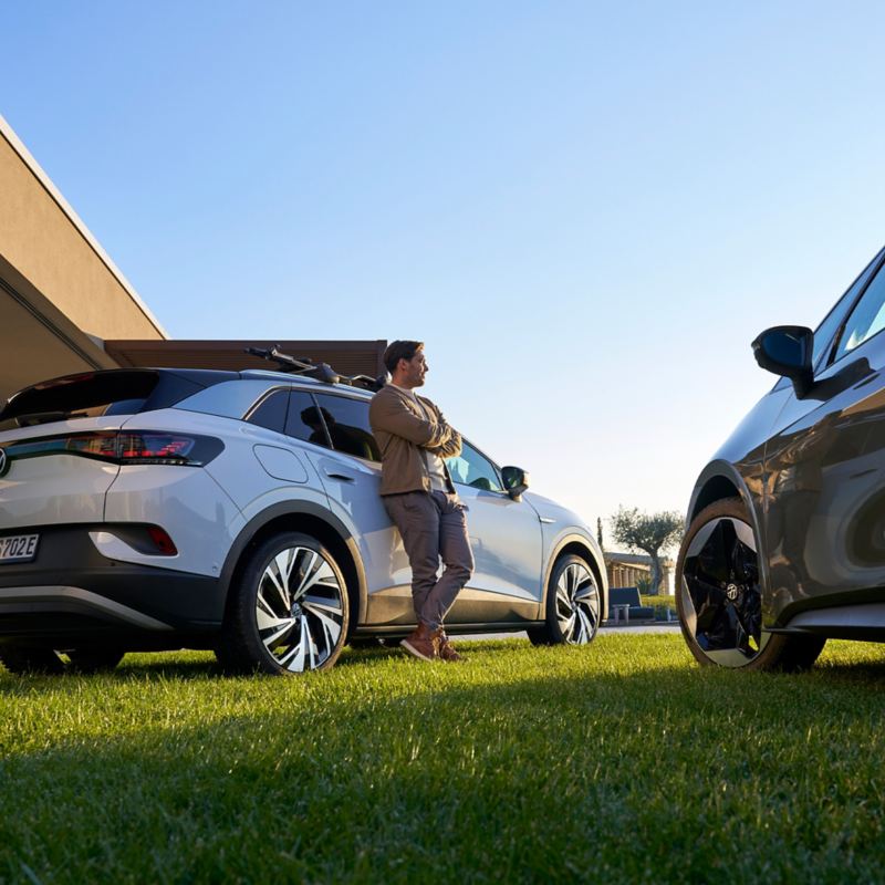 Man leans against a VW ID.4, another VW ID. model in foreground