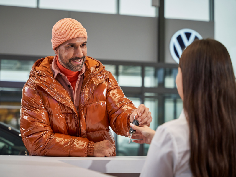 Customer hands car keys to VW service employee – Dialogue reception