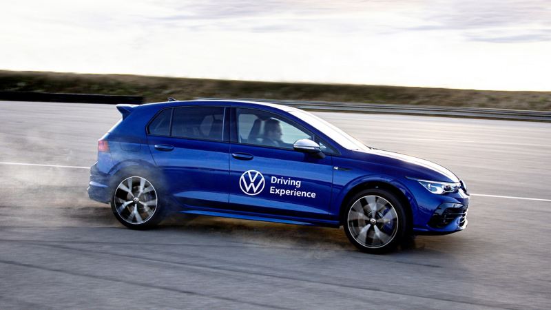 Ein Fahrer genießt das Erlebnis einer Dynamic Driver Experience in einem blauen Volkswagen