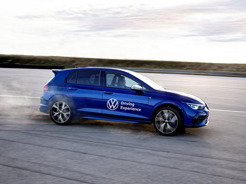 Ein Fahrer genießt das Erlebnis einer Dynamic Driver Experience in einem blauen Volkswagen