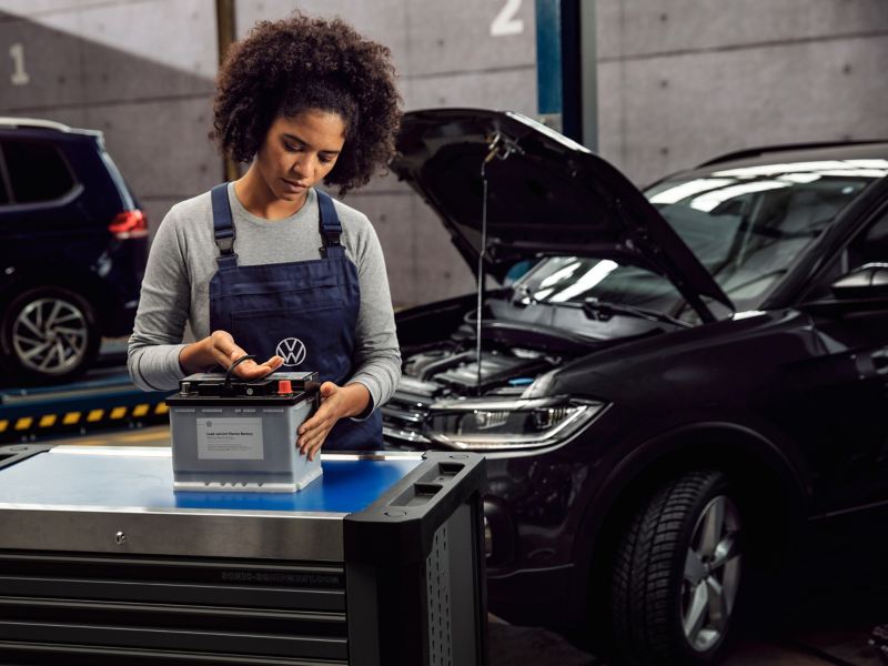 A VW service employee installs a Economy Battery