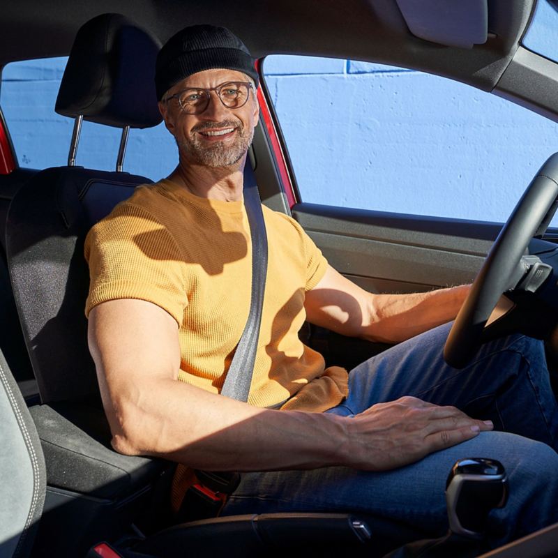 Ein Mann sitzt am Steuer eines VW Autos und freut sich auf seine Driving Experience Tour – Experience Days