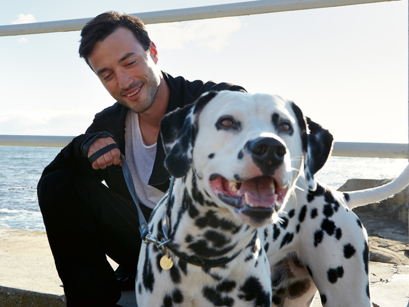 Mann mit Hund am Strand