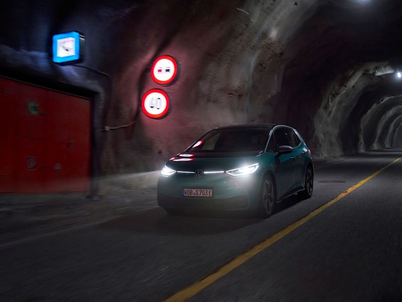 A VW ID.3 with glowing headlights in a tunnel