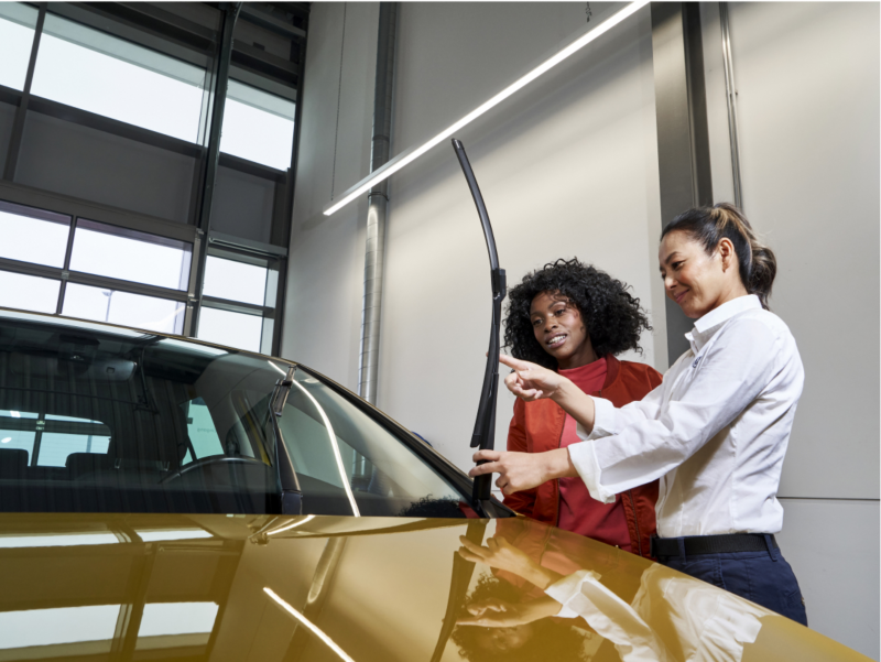 Técnico de servicio de Volkswagen mirando el limpiaparabrisas.