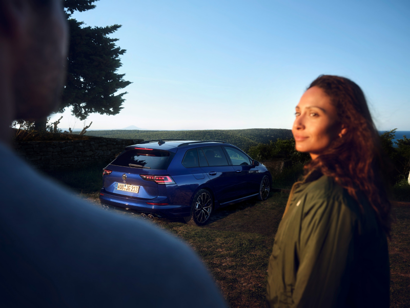 VW Golf R Variant mit Blick auf das Meer, im Vordergrund eine Frau