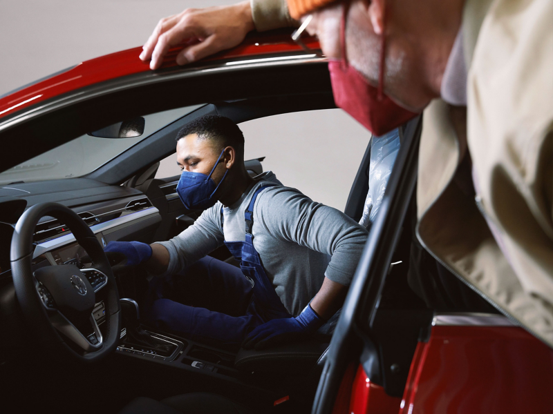 Un employé du service Entretien VW et un client portent des masques dans un atelier