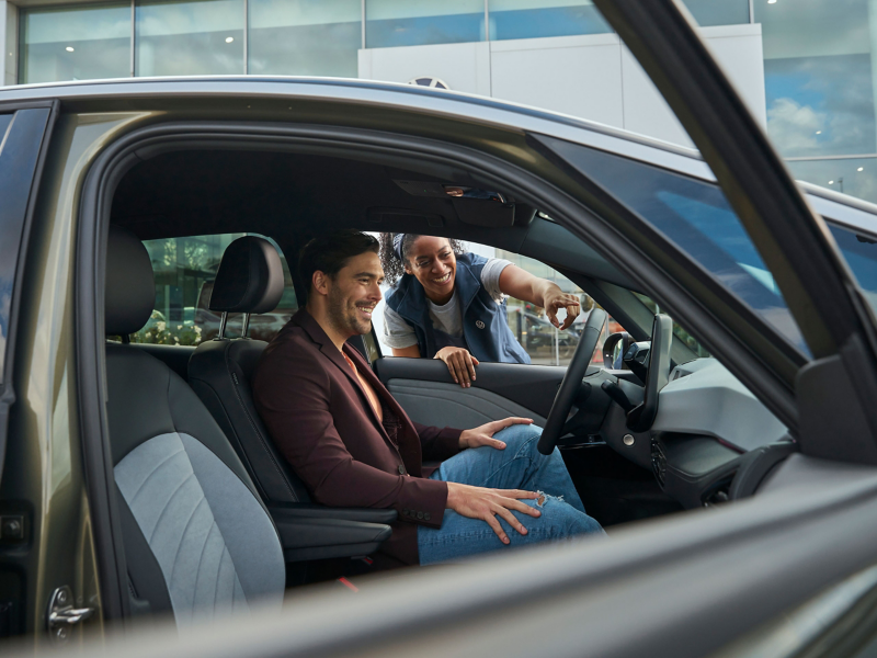 A VW service employee shows a customer updates in his vehicle after a software update